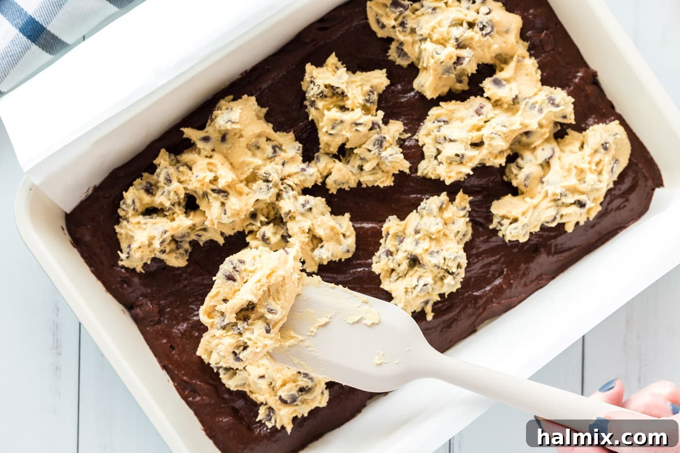 Spoonfuls of cookie dough gently dropped on top of the brownie batter in the baking dish
