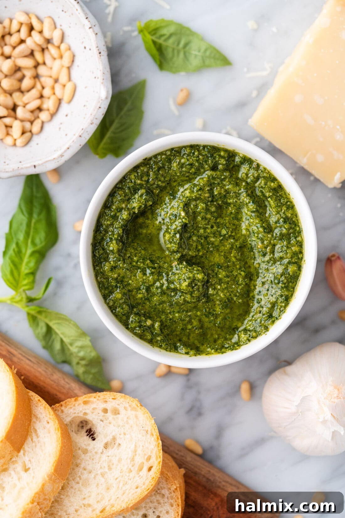 A bowl of vibrant green basil pesto, garnished with fresh basil leaves and pine nuts, showcasing its appealing texture.