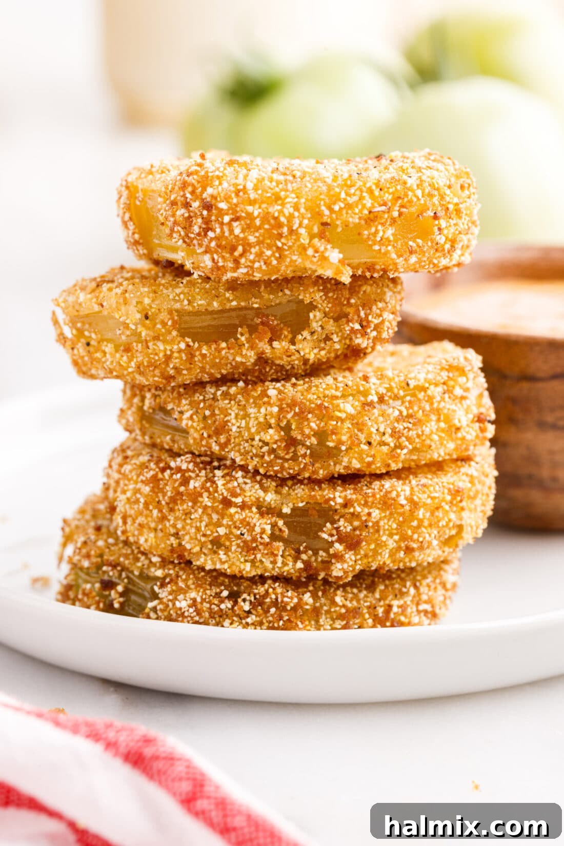 A close-up shot of a stack of golden-brown Fried Green Tomatoes, showcasing their inviting texture