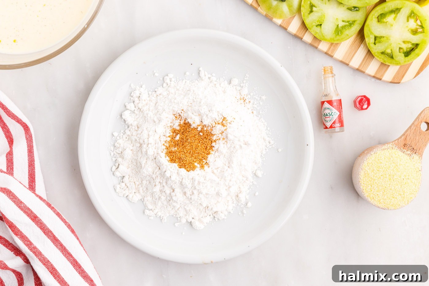 All-purpose flour and Cajun seasoning mixed together in a shallow bowl