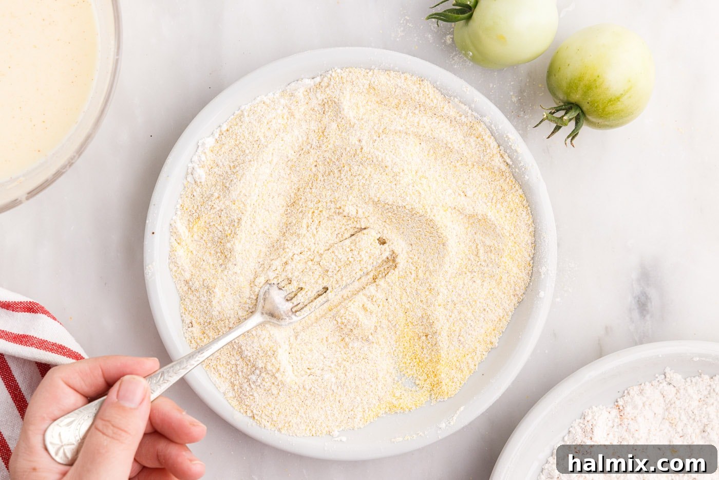 The combined breadcrumb, cornmeal, and Cajun seasoning mixture in a bowl, ready for coating