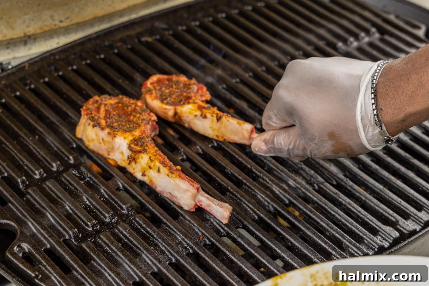 Placing seasoned lamb loin chops directly onto the hot grill grates