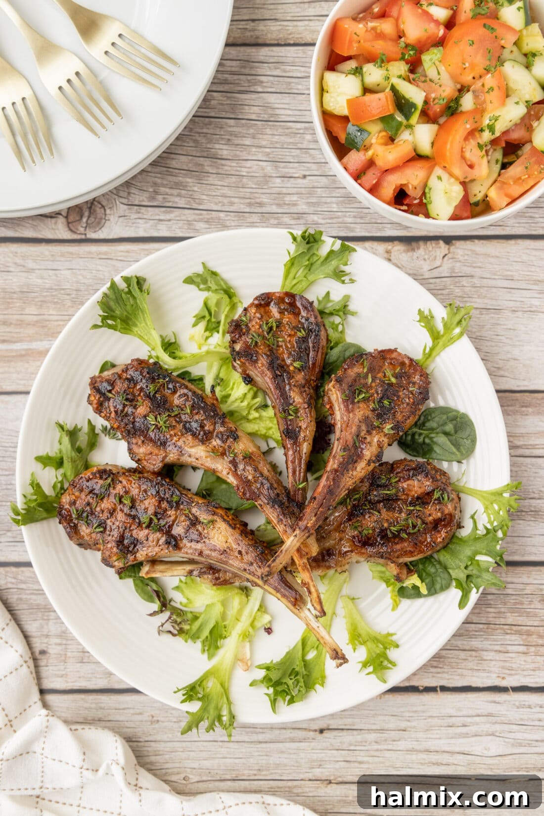 Overhead shot of beautifully grilled lamb chops on a white plate, ready to serve