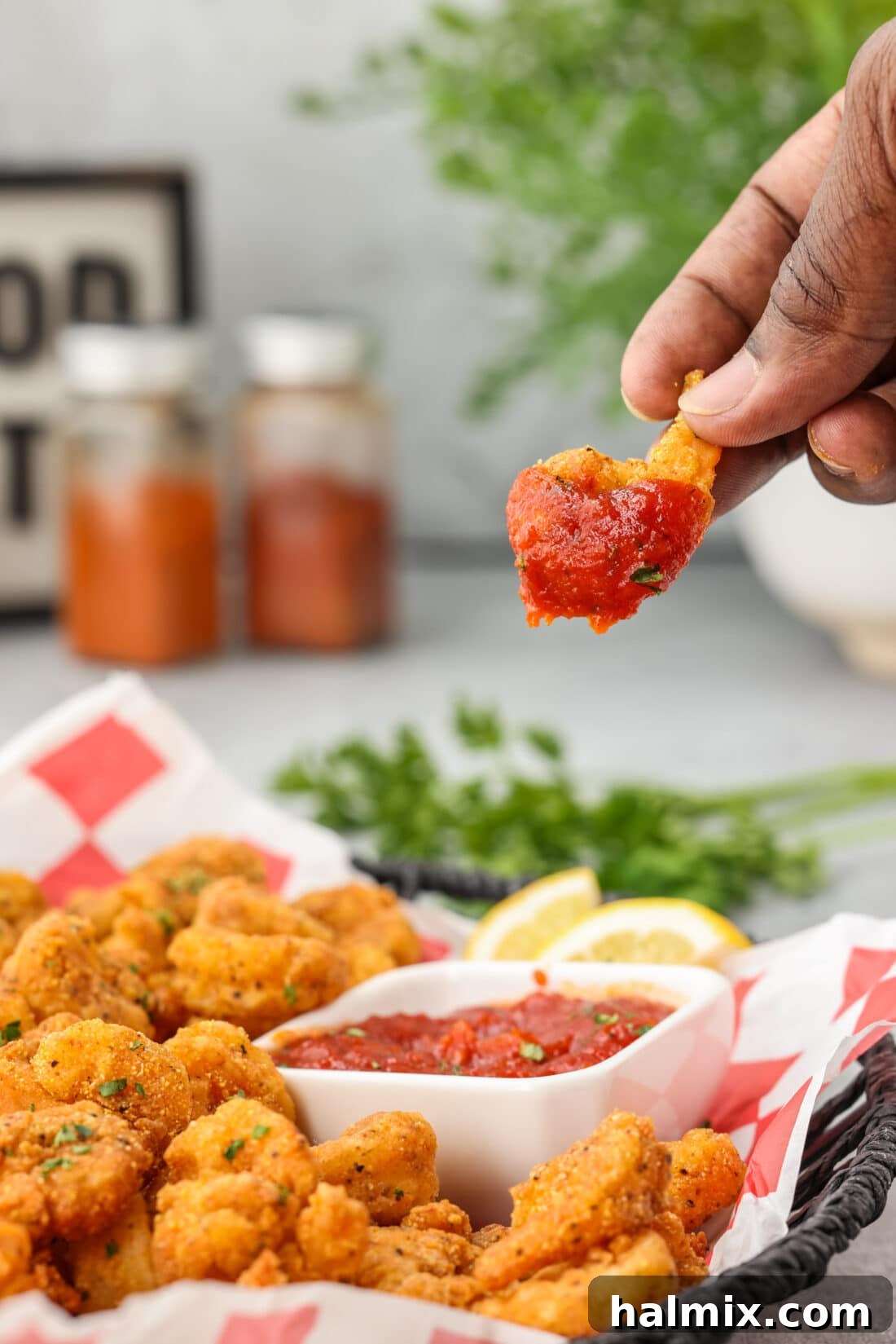 Golden Shrimp Poppers 13 dipping a Popcorn Shrimp in cocktail sauce