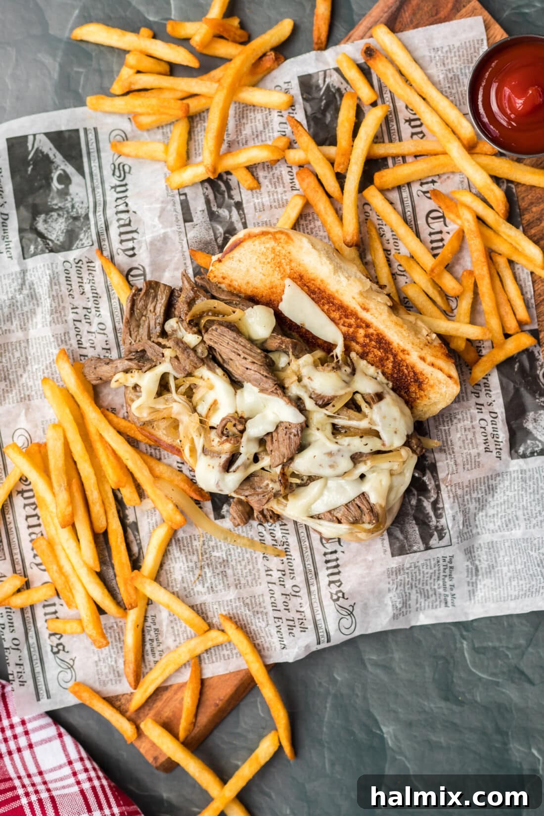 The Quintessential Philly Steak Sandwich 11 Philly Cheese Steak on parchment with fries