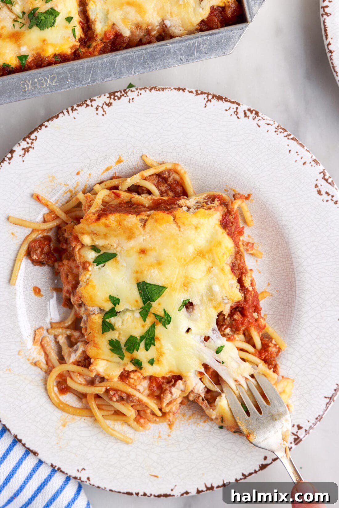 A freshly plated serving of Million Dollar Spaghetti, garnished with fresh parsley, ready to be enjoyed.