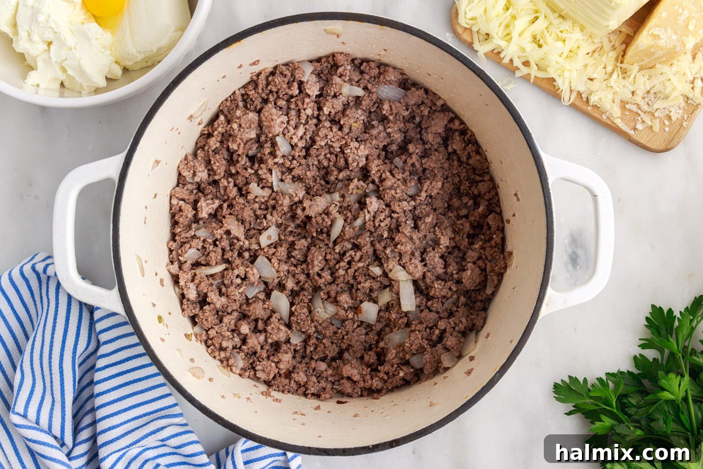 Cooked ground beef and Italian sausage with tender onions, drained of excess fat, in a large skillet.