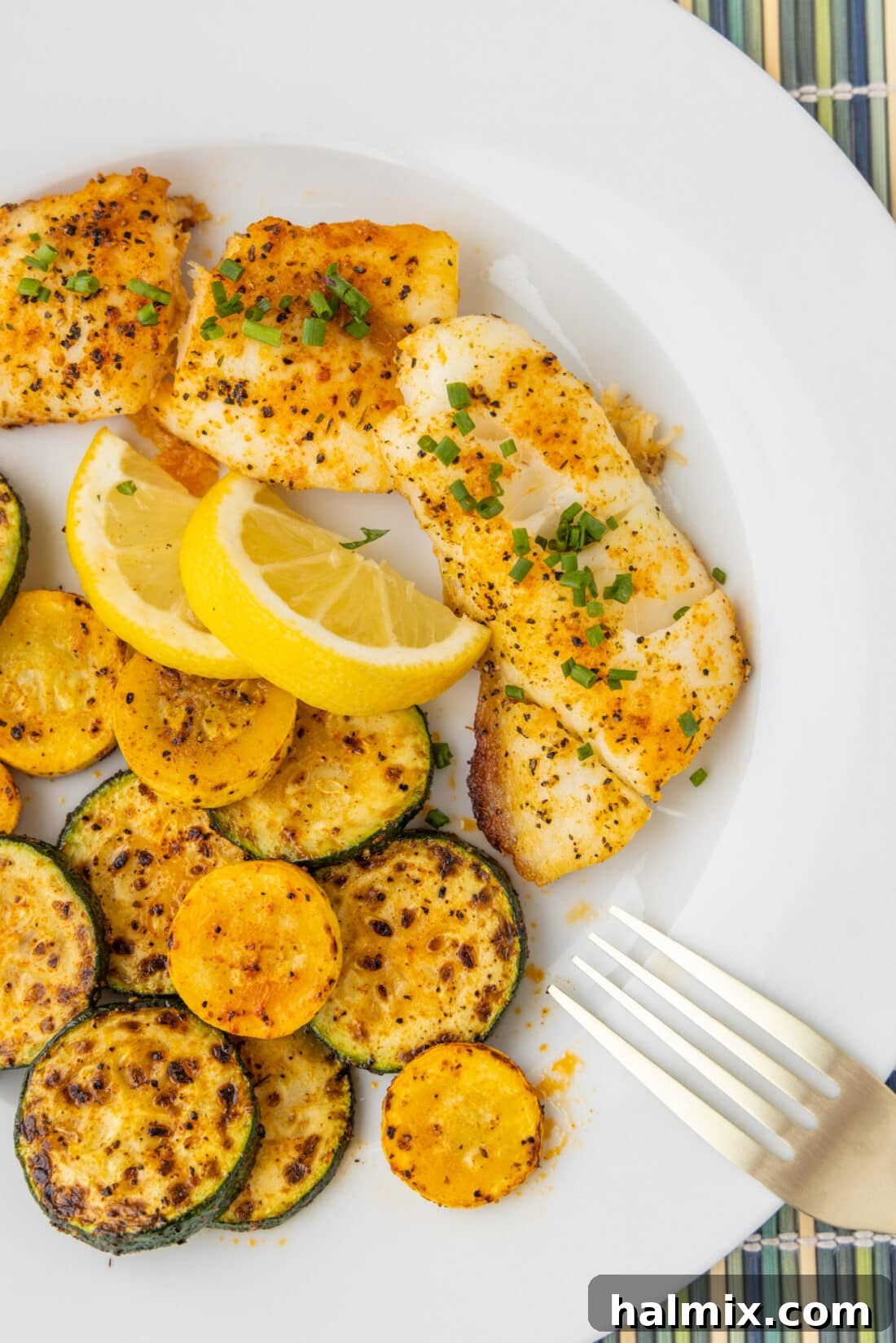 Perfectly baked orange roughy served on a plate, garnished with fresh herbs and lemon