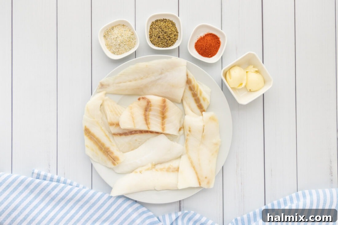 A selection of fresh ingredients for baked orange roughy, including fish fillets, butter, and spices