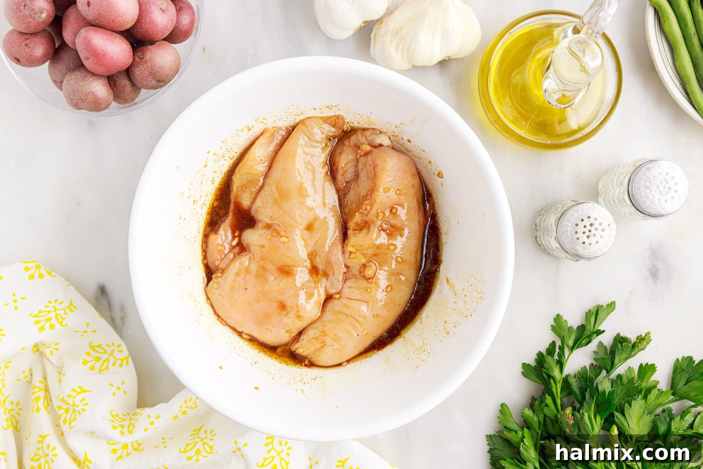 Easy Campfire Foil Meals 6 Chicken breasts marinating in a bowl