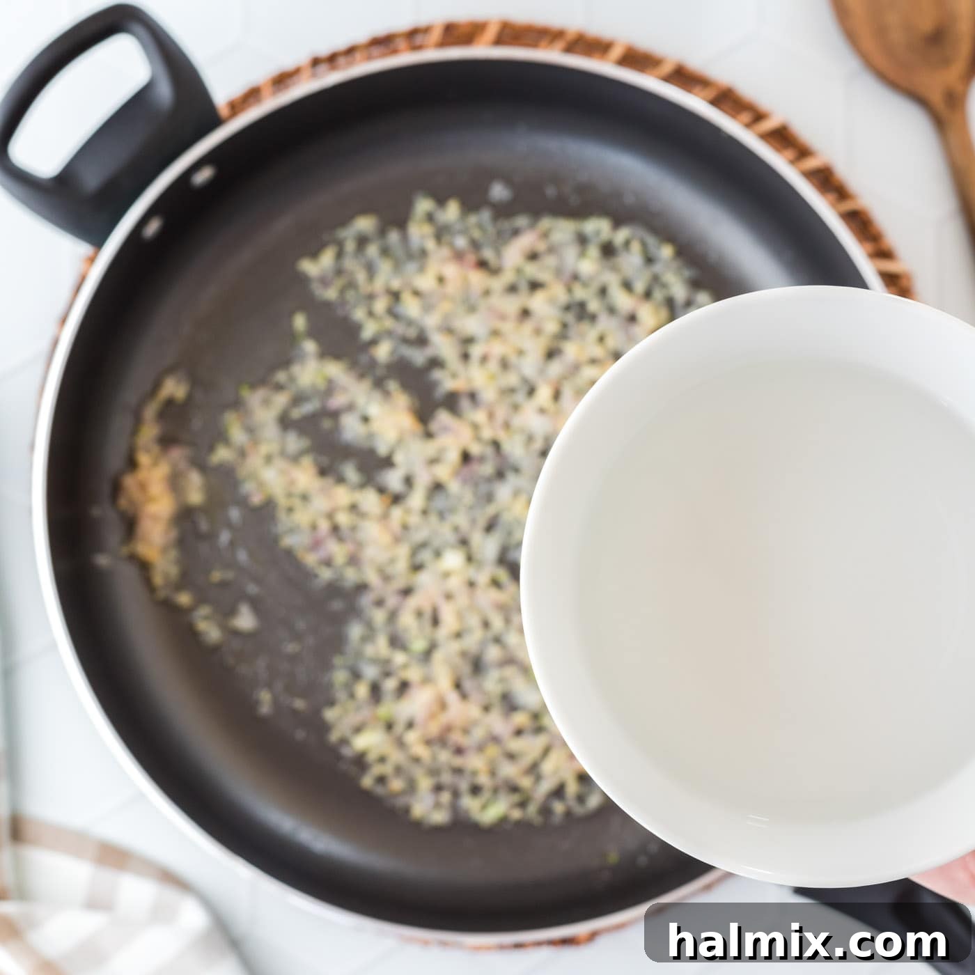 pouring water into pan with shallots and garlic