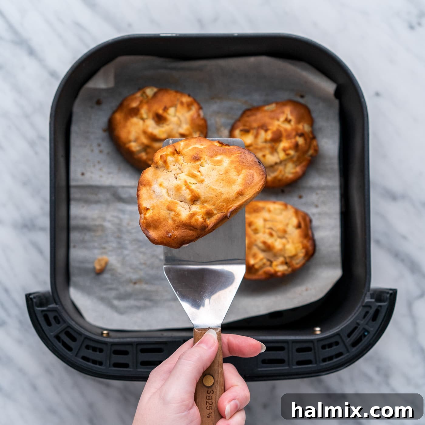 golden air fryer apple fritters on a spatula