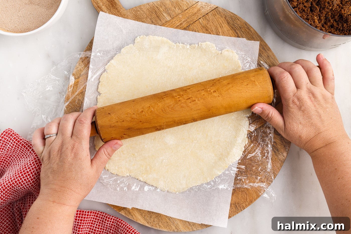 A rolling pin in action, flattening a disc of rugelach dough into a perfect circle.