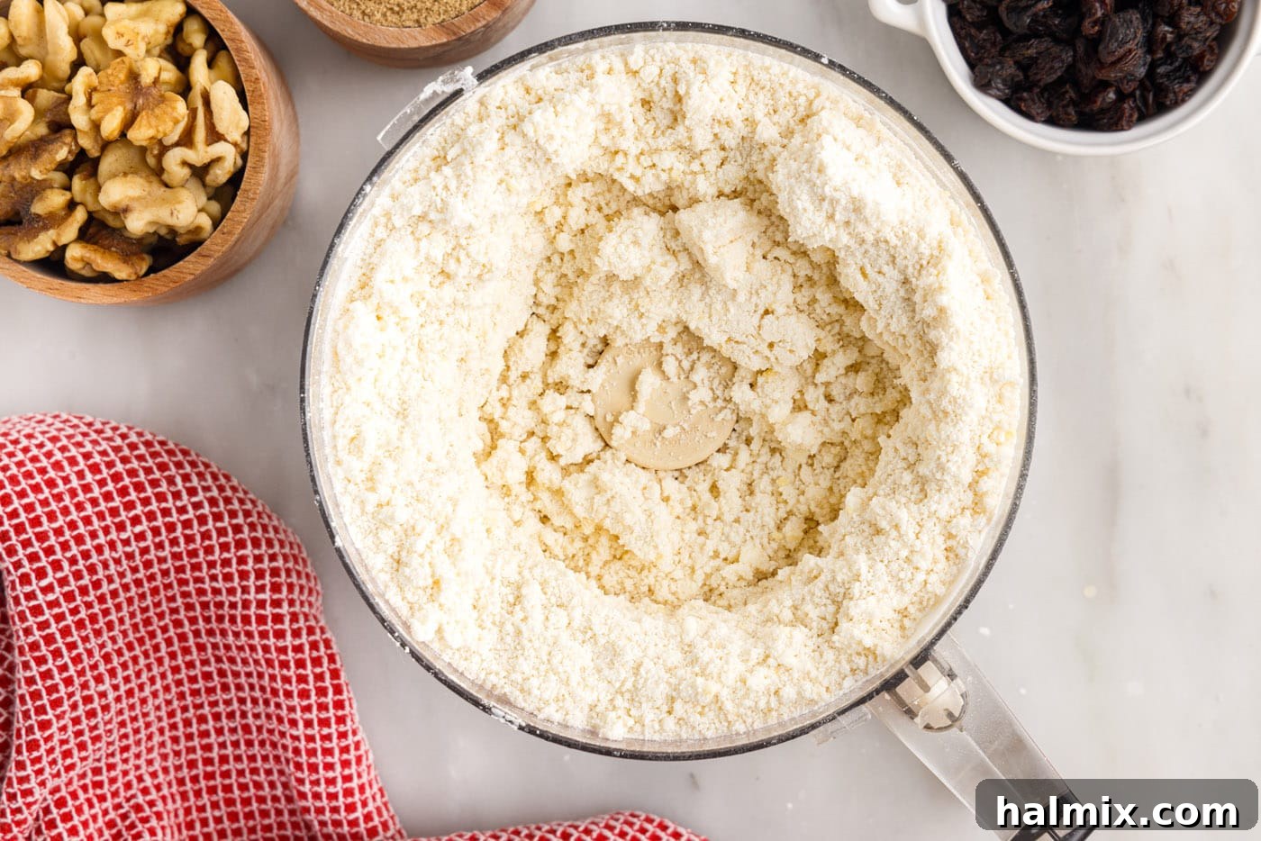 The rugelach dough after the egg yolk has been incorporated, still crumbly but able to hold together.