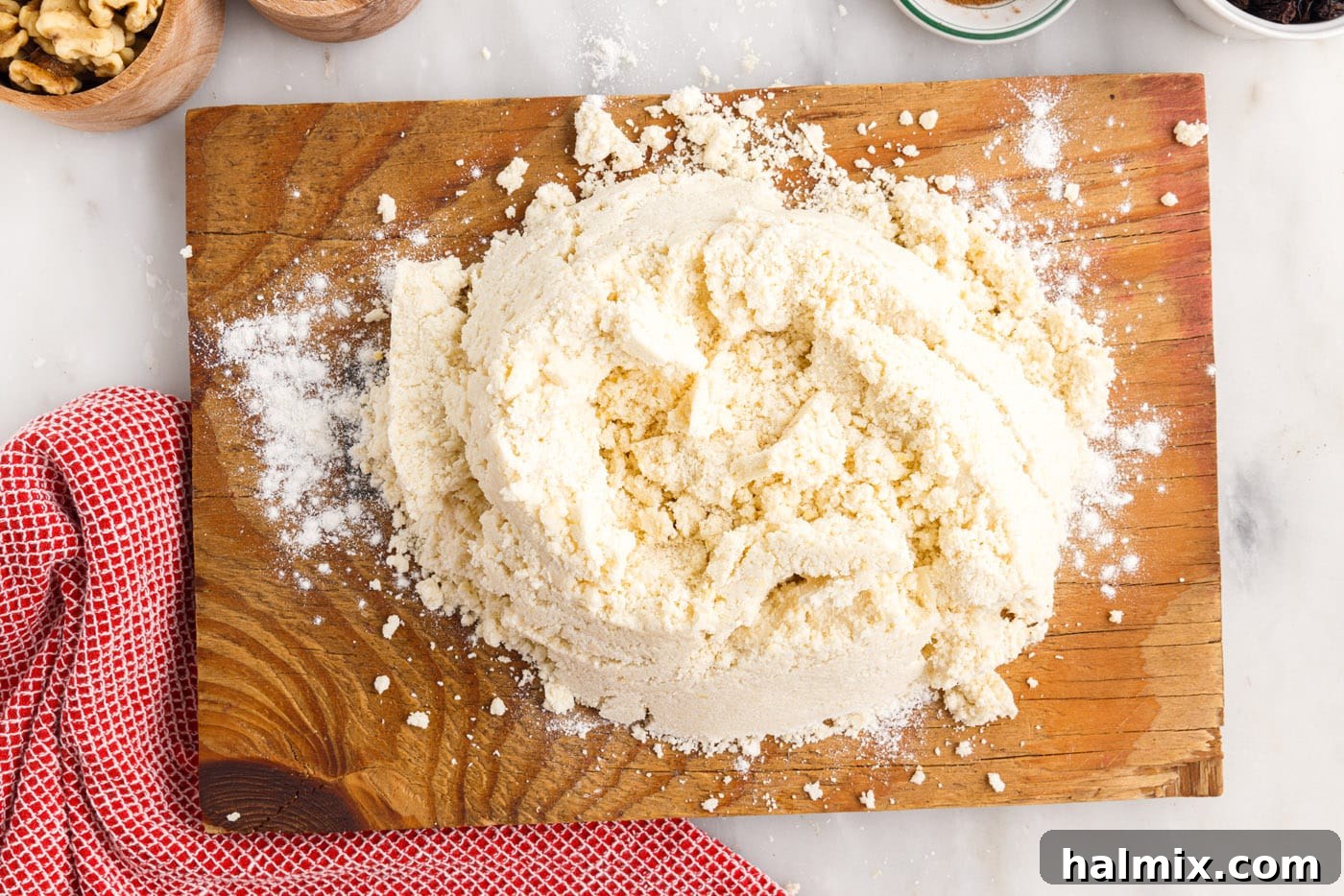 The rugelach dough is turned out onto a cutting board, ready to be gathered into a ball.