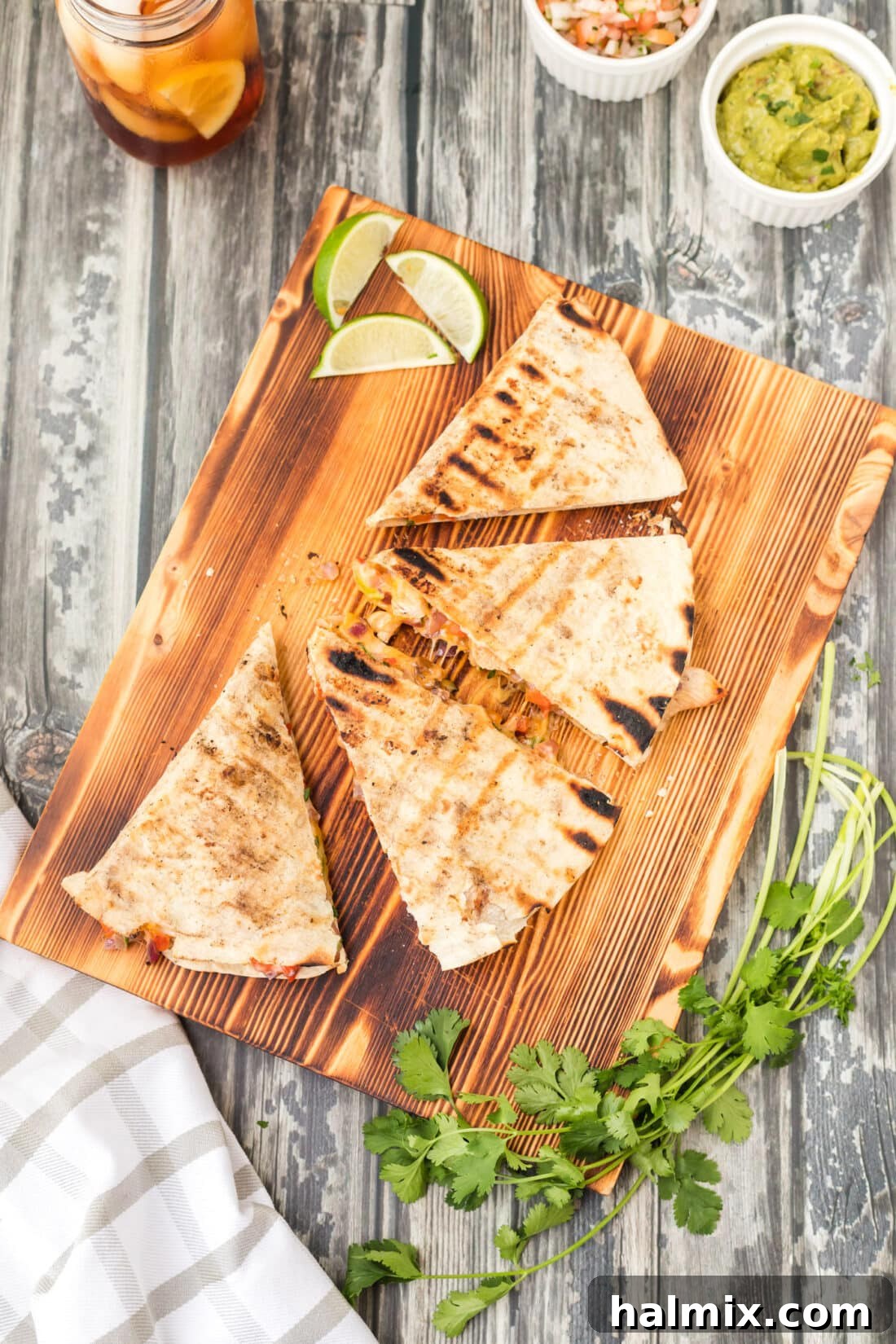 Grilled Chicken & Cheese Fiesta 3 Two grilled chicken quesadillas on a wooden cutting board, sliced into triangles