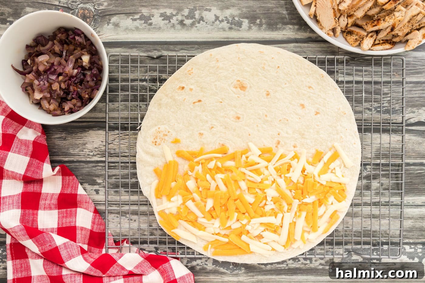 Grilled Chicken & Cheese Fiesta 8 Shredded cheese covering one half of a large flour tortilla shell