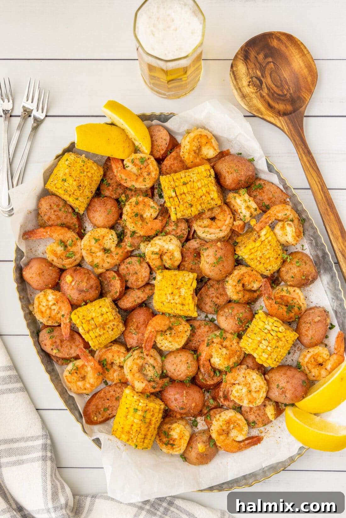 A bountiful Southern Shrimp Boil arranged artfully on a large white platter, ready to be served, highlighting the fresh and cooked ingredients.