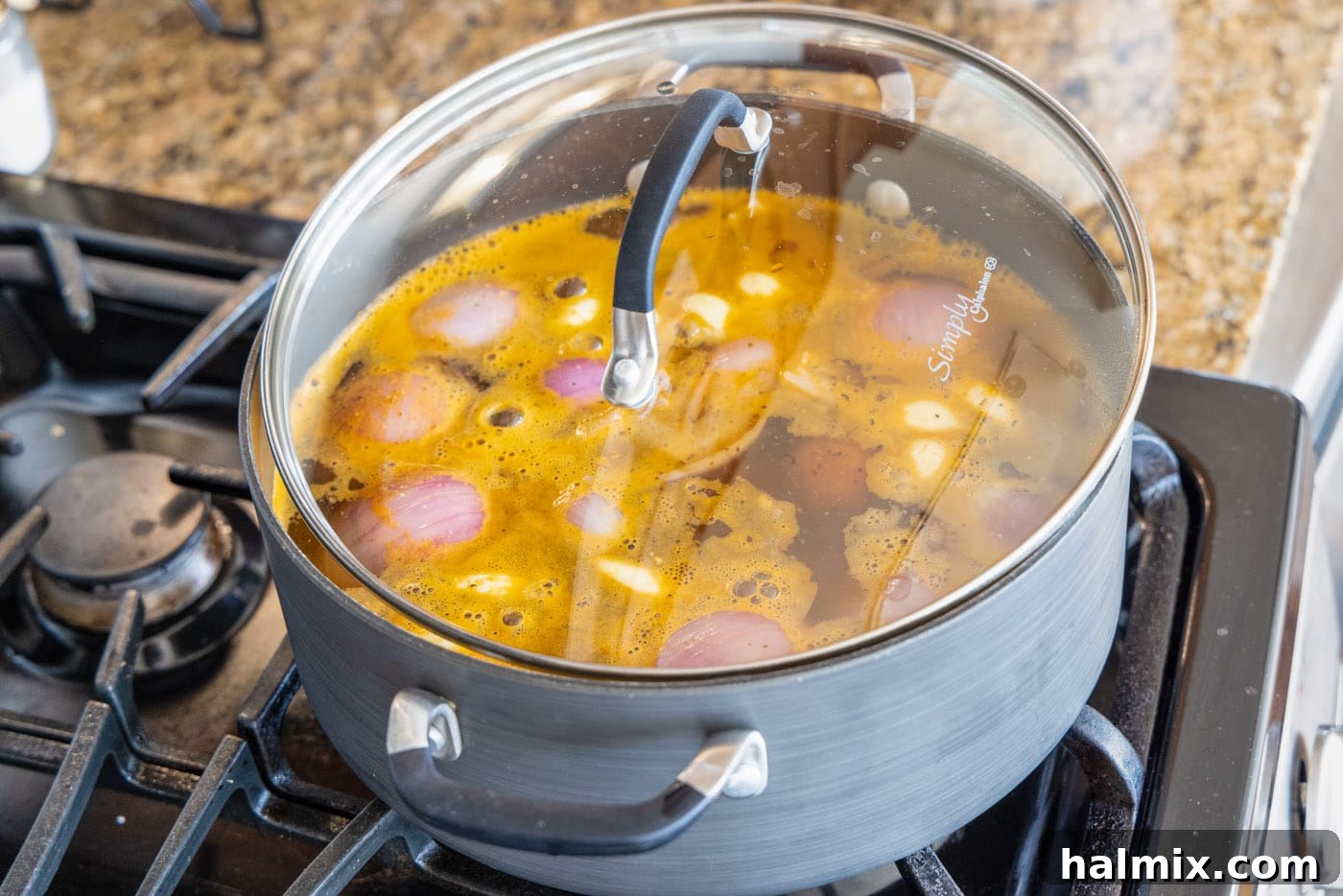A large stockpot with its lid slightly ajar, allowing steam to escape while the ingredients for the shrimp boil simmer.