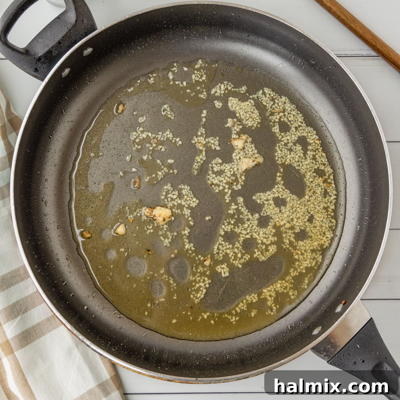 Minced garlic and bourbon simmering in a skillet