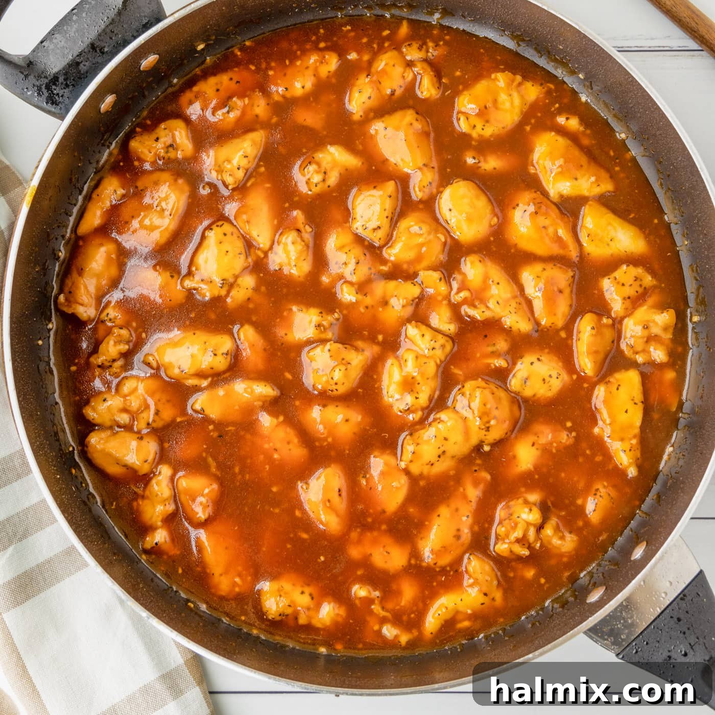 Bourbon Chicken coated in sauce in a skillet, ready to serve