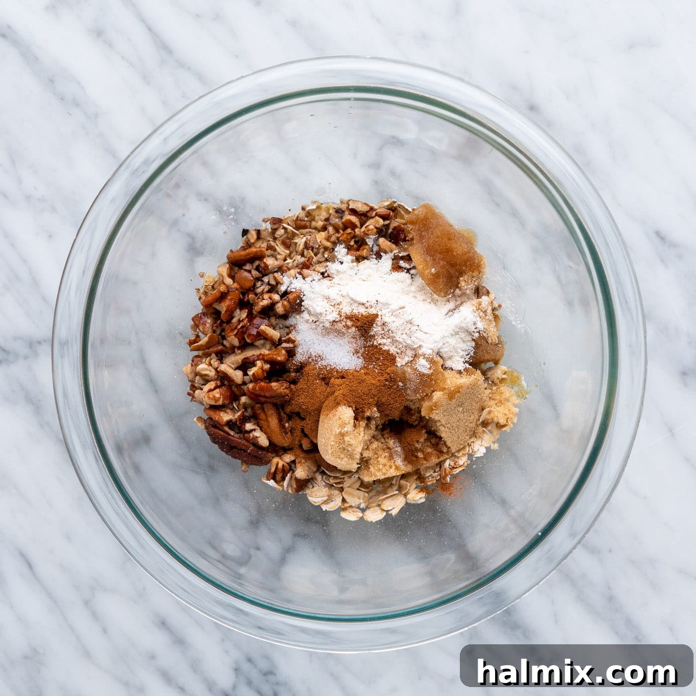 Air Fried Apple Delights 7 A bowl filled with the dry ingredients for the air fryer baked apple filling: oats, pecans, brown sugar, flour, cinnamon, and salt.