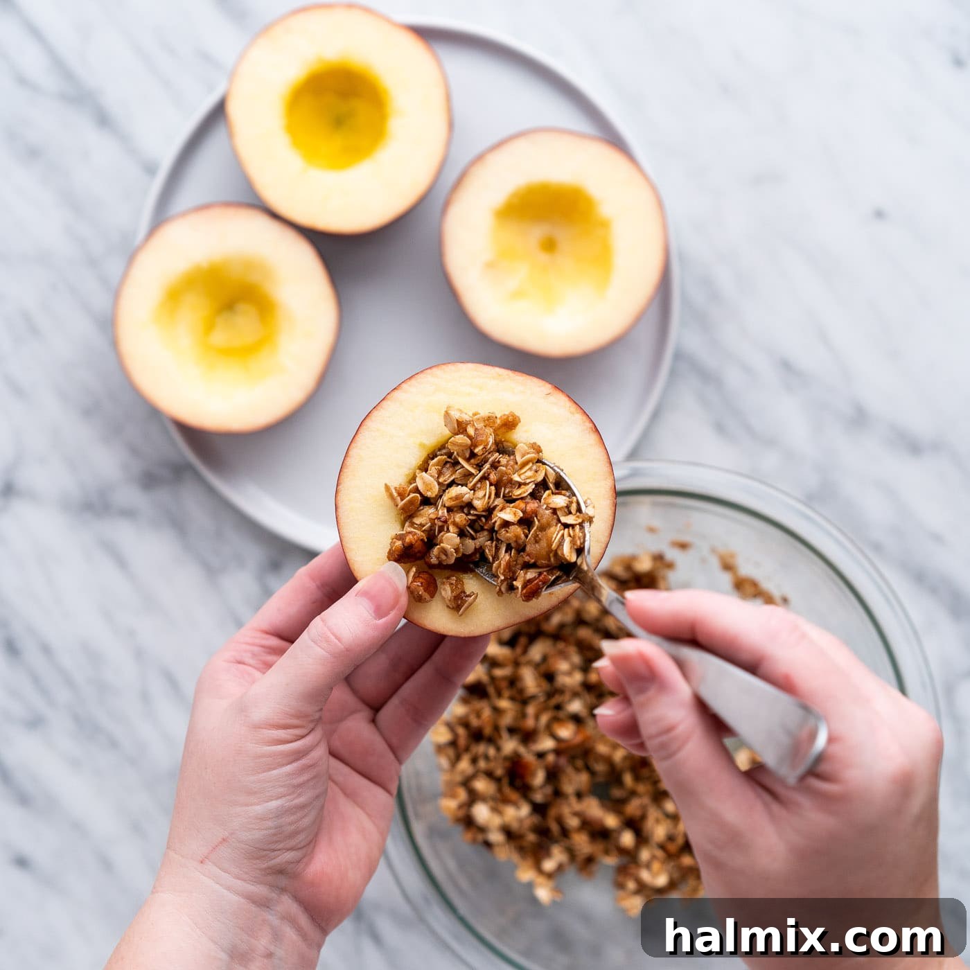Air Fried Apple Delights 9 A hand scooping the walnut and brown sugar filling into a cored apple half, ready for air frying.
