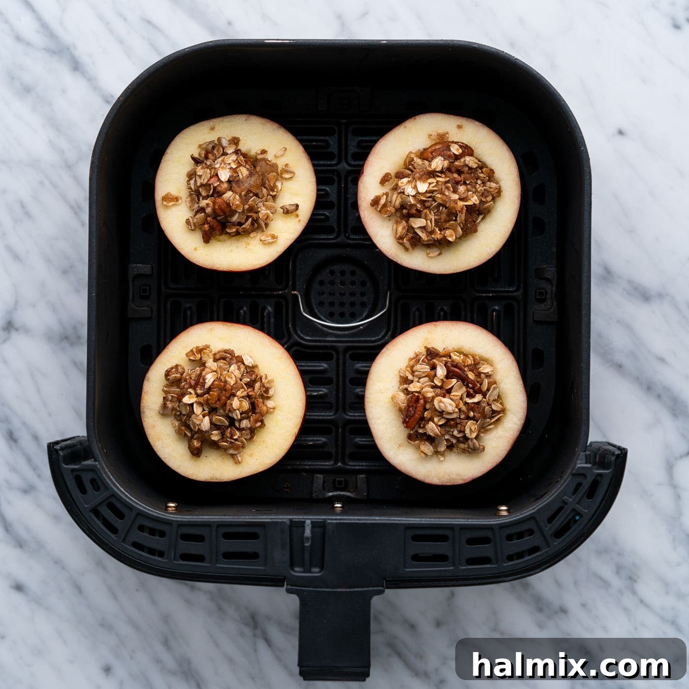 Air Fried Apple Delights 10 Stuffed baked apples arranged in the basket of an air fryer, midway through cooking.