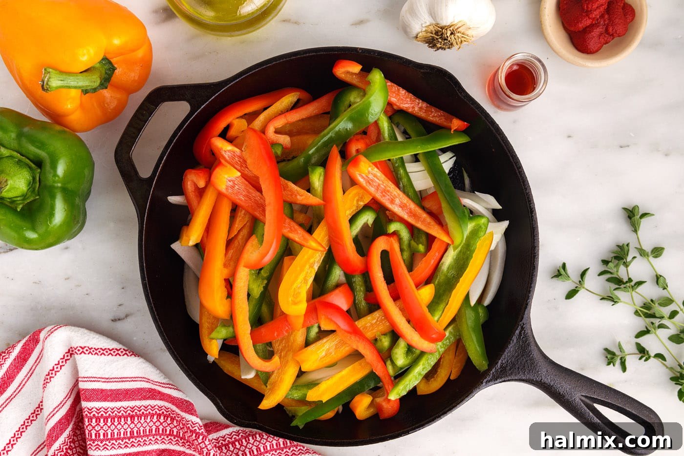 bell peppers and onions softening in a skillet