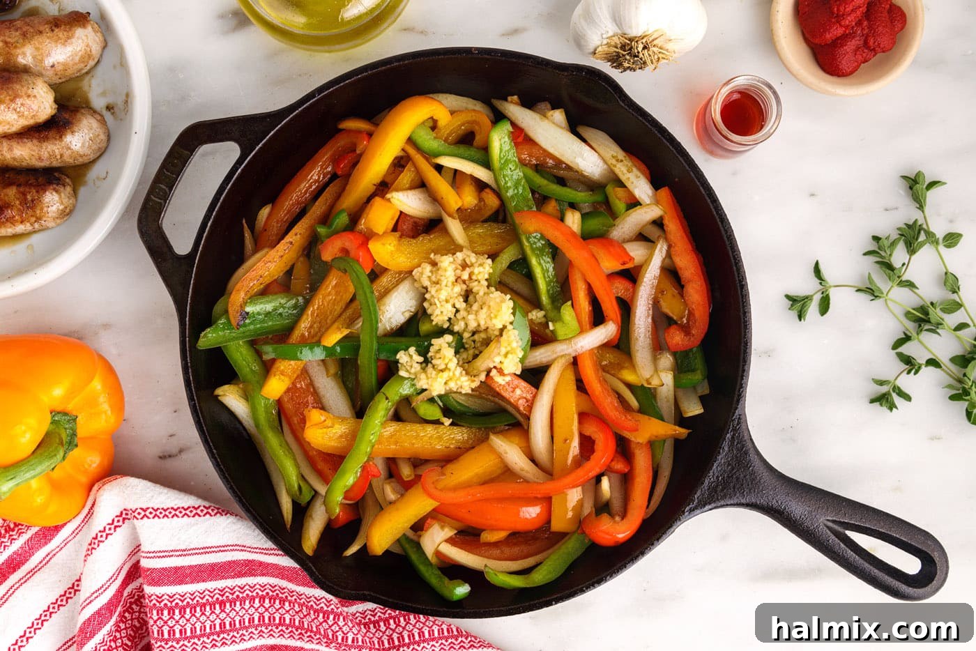 garlic, peppers, and onions sautéing in a skillet