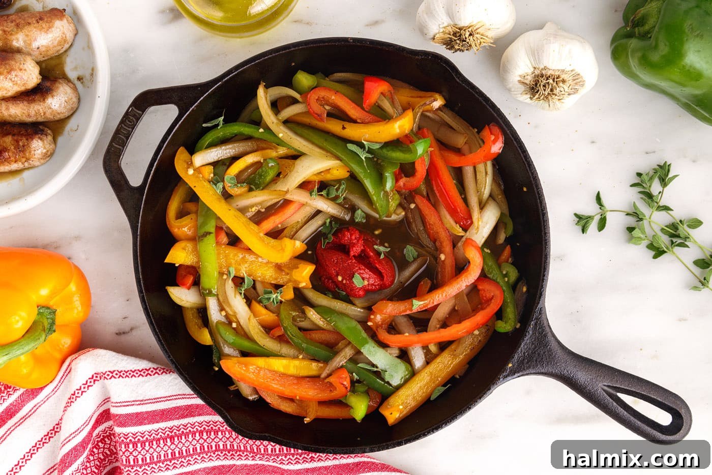 tomato paste added to peppers and onions in a skillet, mixing into the sauce