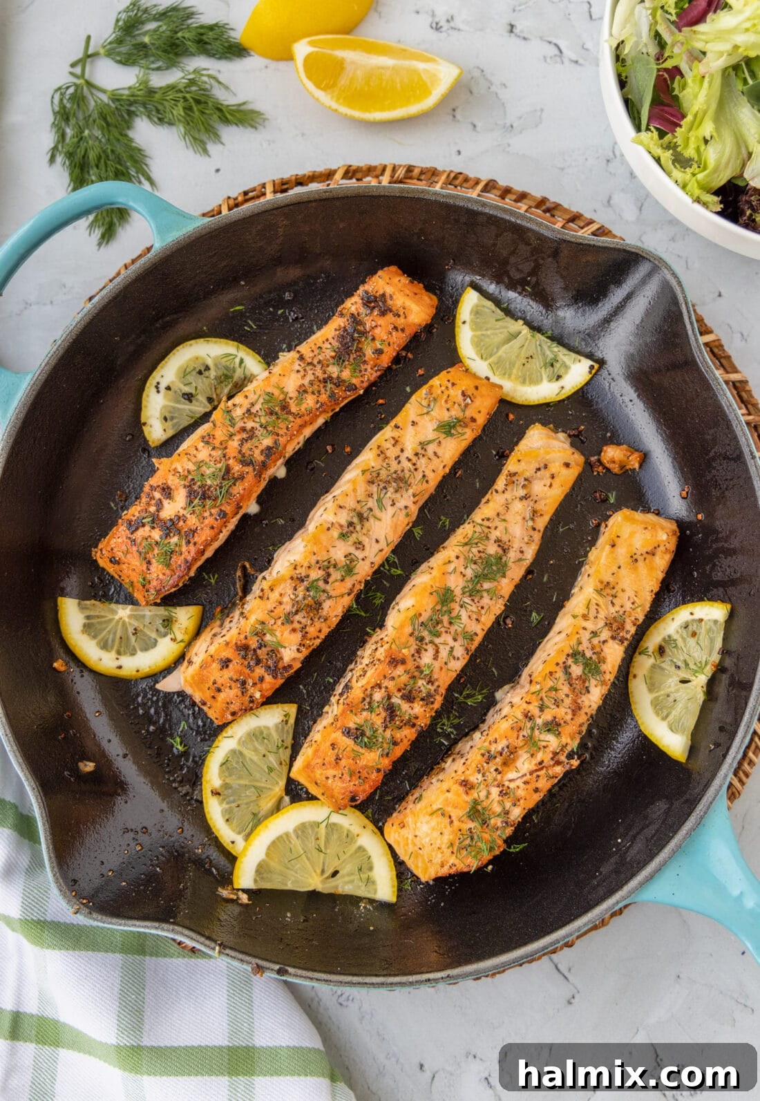 Perfectly Golden Seared Salmon 3 Pan Seared Salmon in a skillet with lemon wedges
