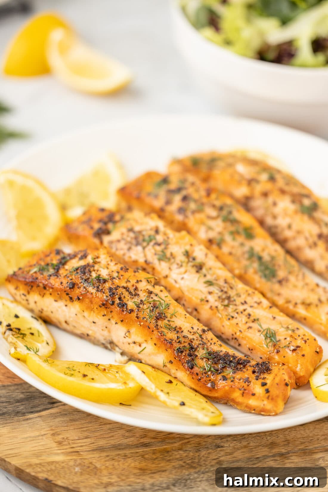 Perfectly Golden Seared Salmon 7 Pan Seared Salmon on a white plate with lemon and herbs