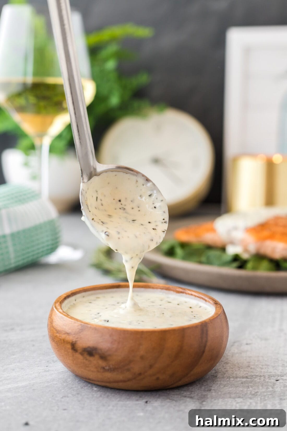 Velvet Rosemary Cream 2 A glistening ladle filled with homemade Rosemary Cream Sauce, ready to pour over a gourmet meal. This rich, smooth sauce promises a burst of fresh herb flavor.