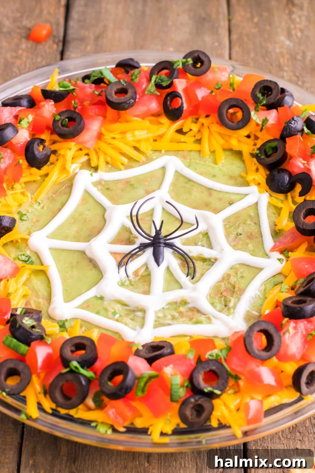 A close-up, tempting shot of the Spider Web Taco Dip, highlighting the intricate sour cream web, vibrant guacamole, and colorful toppings, with a focus on the delicious textures.