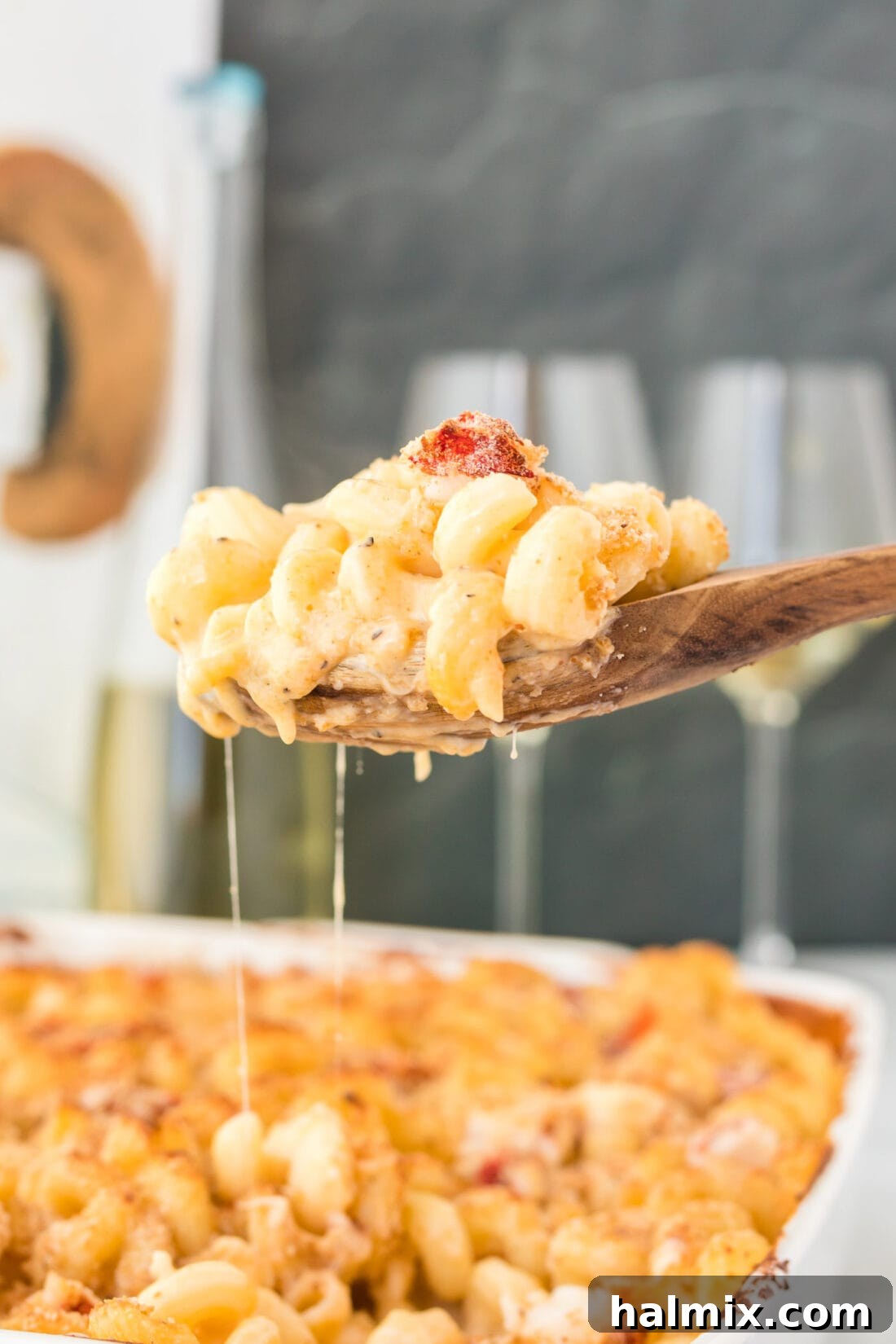 serving spoon of Lobster Mac and Cheese, showcasing creamy texture and lobster chunks