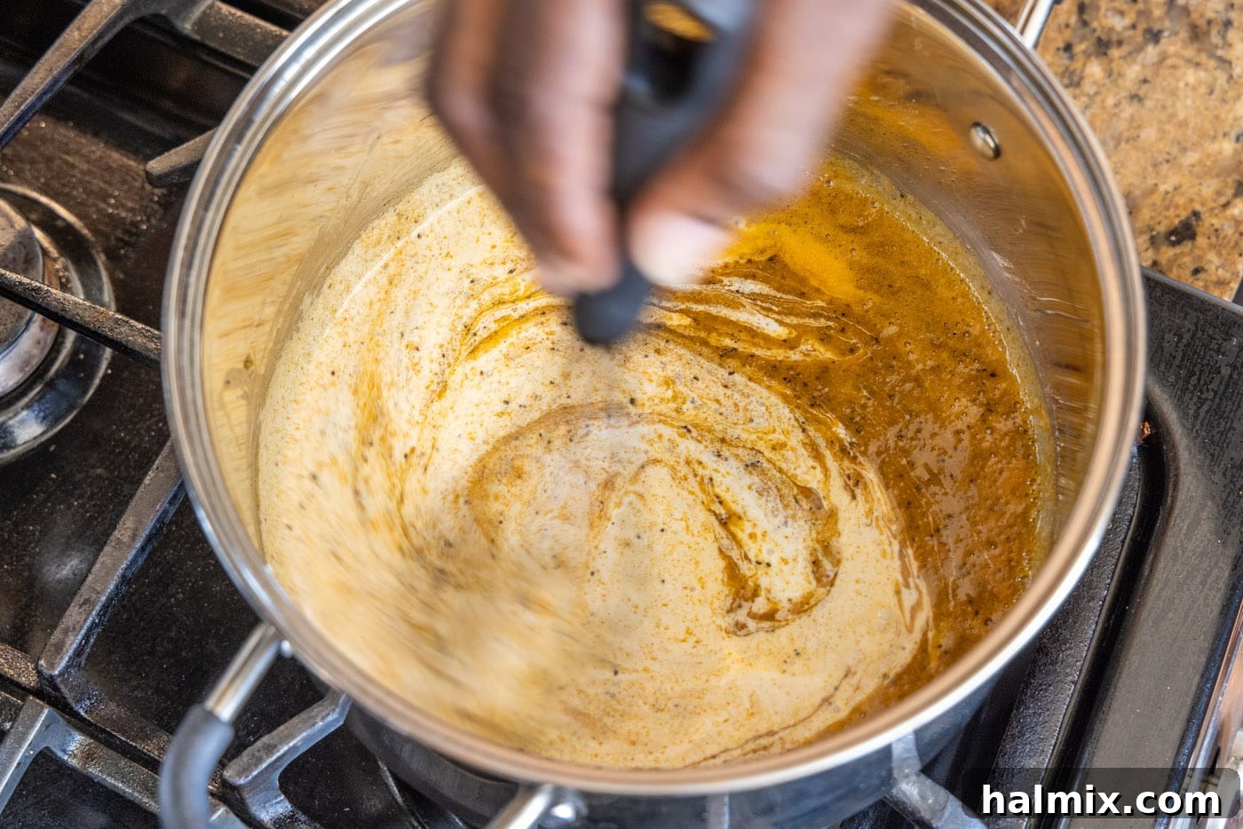 stirring heavy cream and milk into the roux base for the cheese sauce
