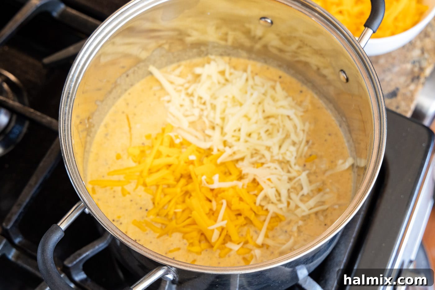 shredded cheese melting into the creamy mac and cheese roux