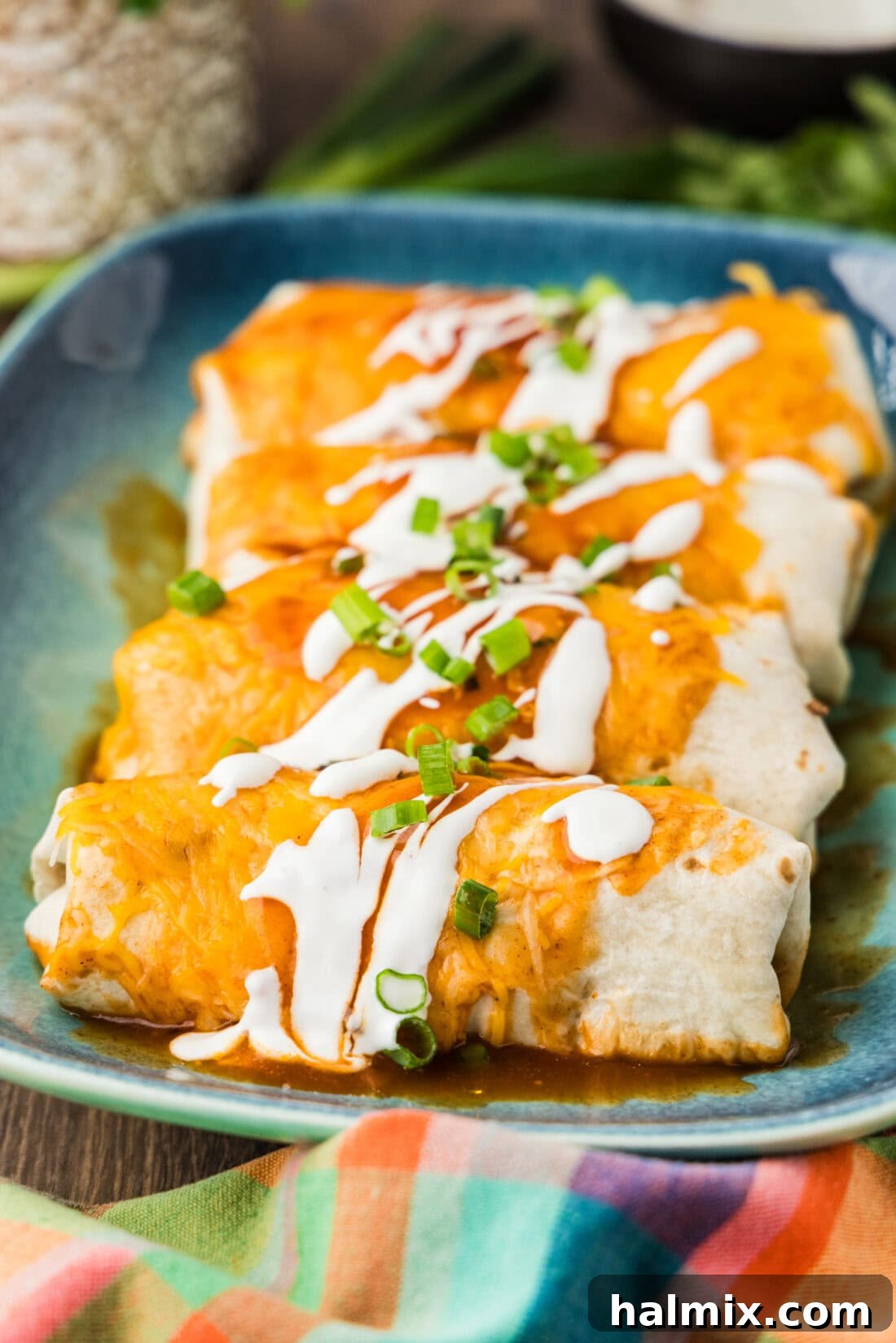 A close up photo of copycat Taco Bell enchiritos resting on a platter, showcasing rich sauce and melted cheese.