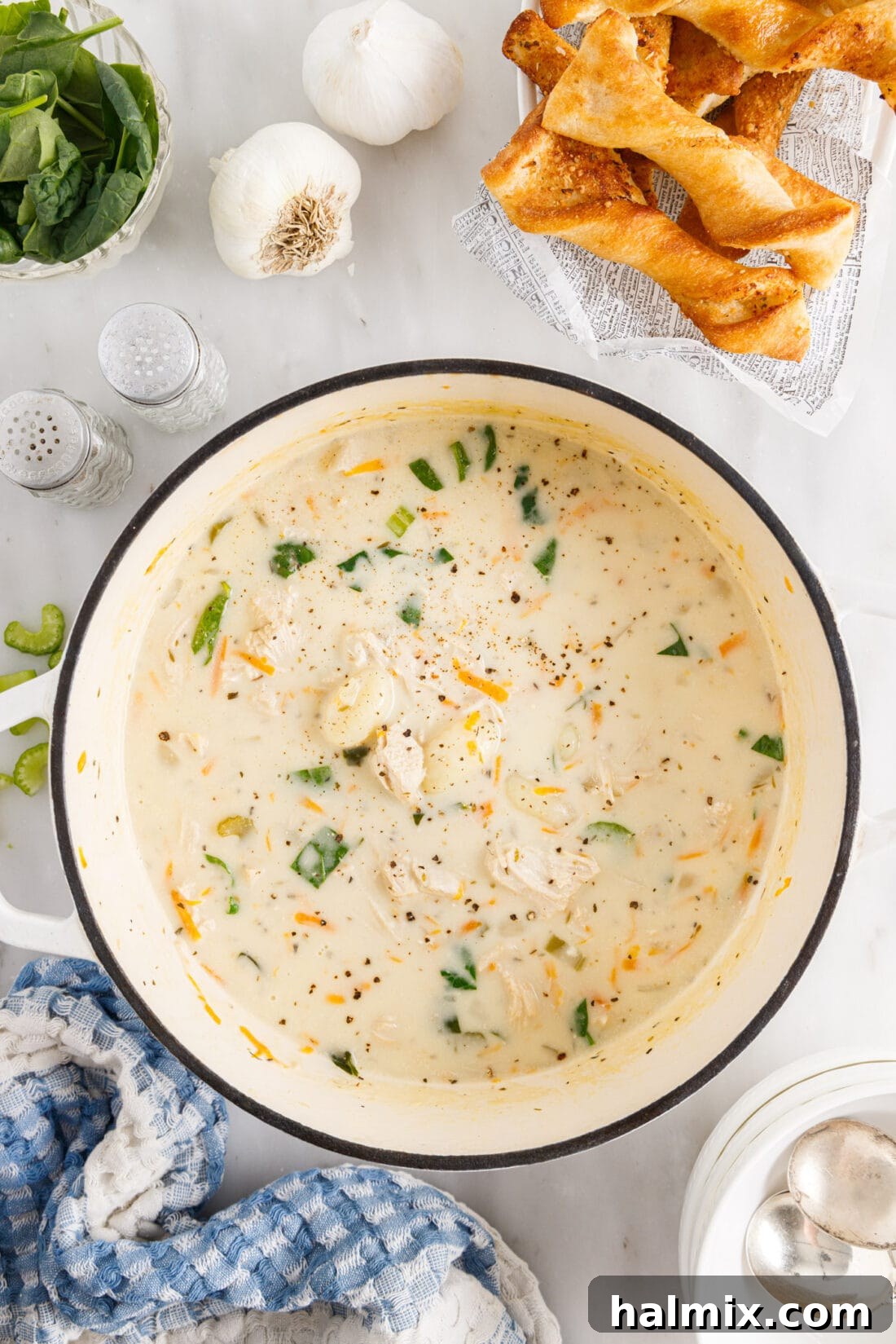 A rustic pot filled with creamy chicken gnocchi soup, ready to be served, highlighting the rich texture and vibrant ingredients.