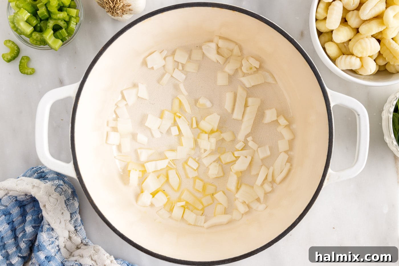 Sautéing diced white onion in olive oil in a large stockpot until translucent.