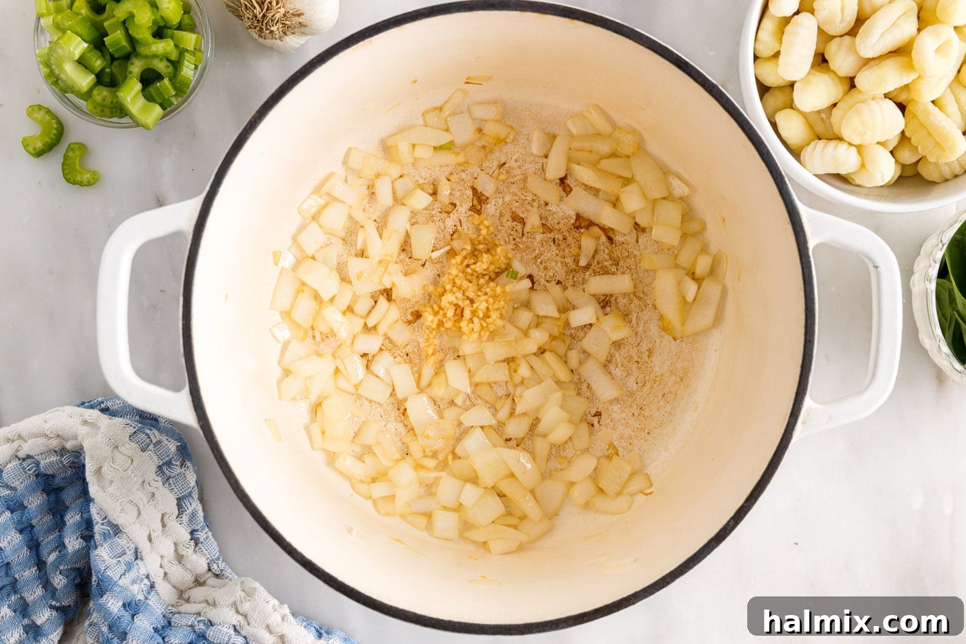 Close-up of sautéed onion and minced garlic in a stockpot, radiating a delicious aroma.