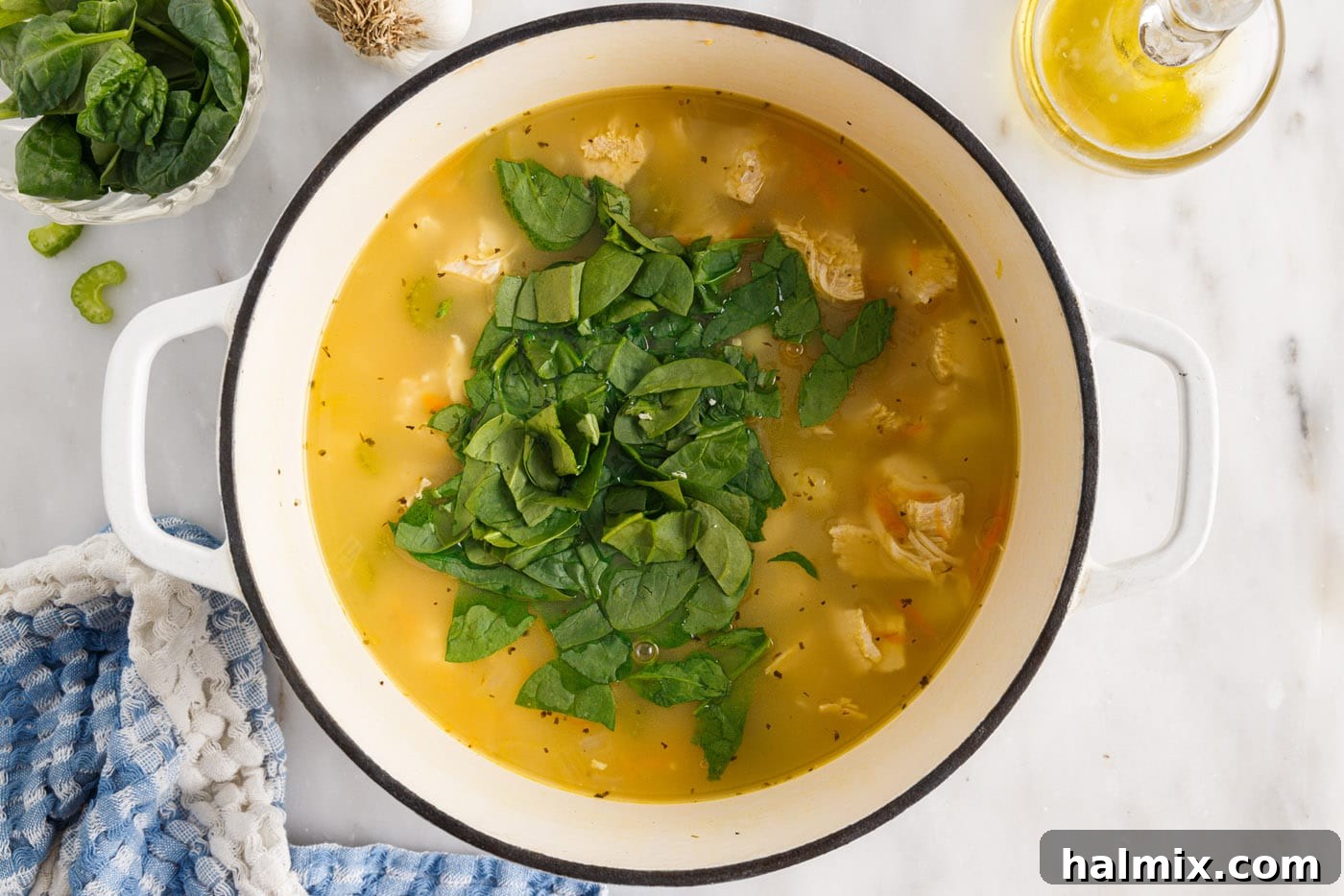 Fresh baby spinach leaves added to the simmering creamy chicken gnocchi soup.