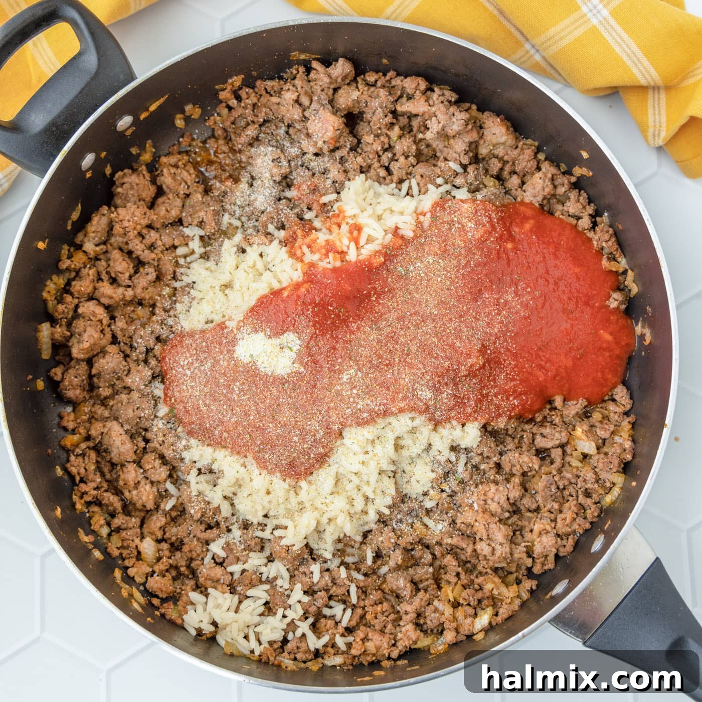 Beef mixture with tomato sauce stirred together in a skillet, ready to be stuffed
