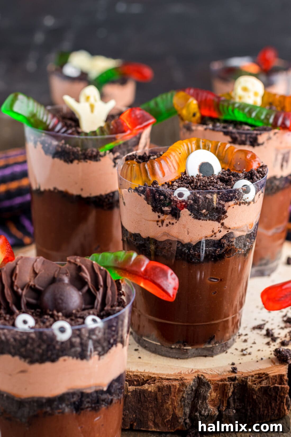 Delicious Halloween Dirt Cups artfully arranged on a rustic wood board, ready for a spooky celebration.