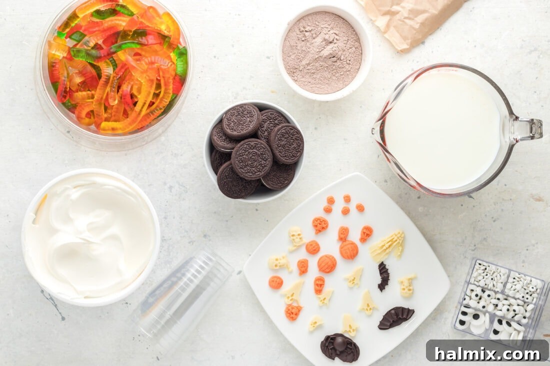 A vibrant flat lay of all the essential ingredients needed for crafting Halloween Dirt Cups, including pudding mix, Oreos, and various candies.