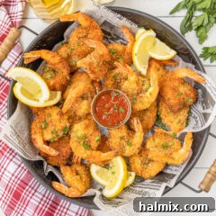 Round tray full of golden-brown Butterfly Shrimp