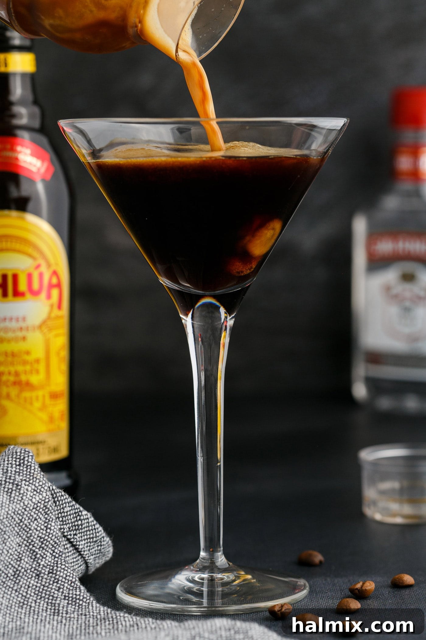 The final step: straining the perfectly frothy Espresso Martini into a elegant martini glass.