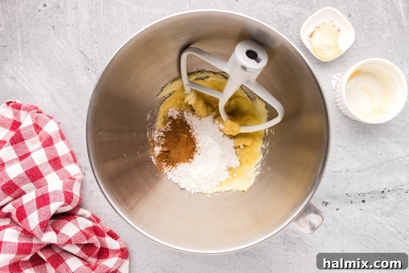 Powdered sugar and cinnamon being added to the honey butter mixture and starting to mix