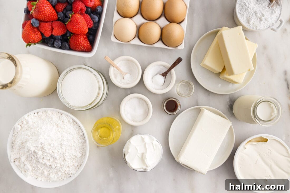 A collection of fresh ingredients laid out, including flour, eggs, milk, sugar, butter, cream cheese, and an assortment of berries, ready for making Chantilly Cake.